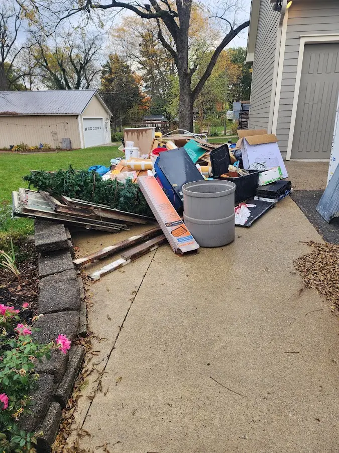 Dumpster being loaded with debris for 12 Yard Dumpster Rental in Matthews